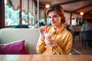 Attractive woman drinks a cocktail from the straw