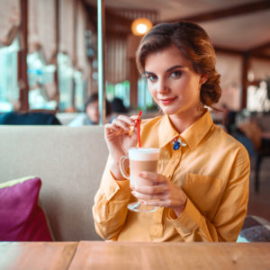 Attractive woman drinks a cocktail from the straw