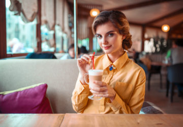 Attractive woman drinks a cocktail from the straw
