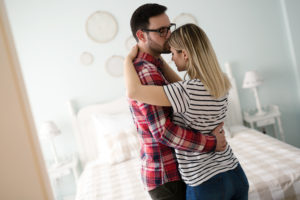 Married couple in love cuddling and hugging at home