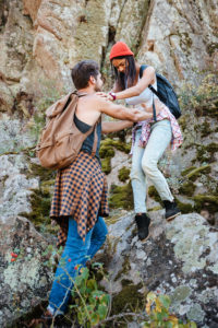 Full length man and woman walking on rock