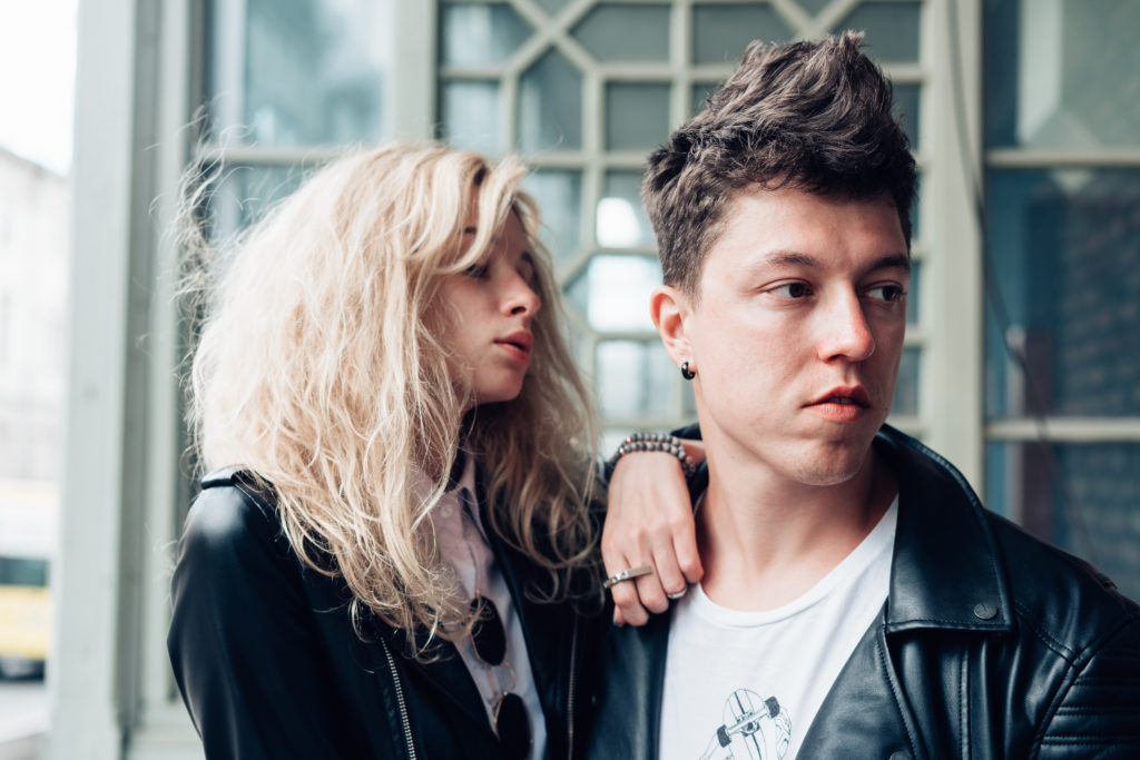 Guy and girl in black jackets on a city street