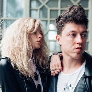 Guy and girl in black jackets on a city street