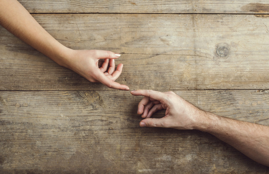 Hands of man and woman touching.