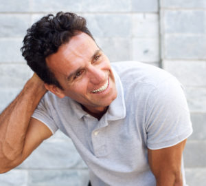 Handsome older man laughing with hand in hair