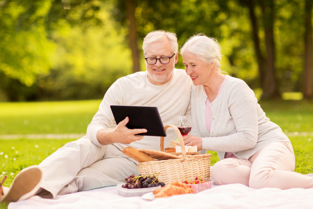 happy senior couple having picnic at summer park