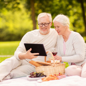 happy senior couple having picnic at summer park