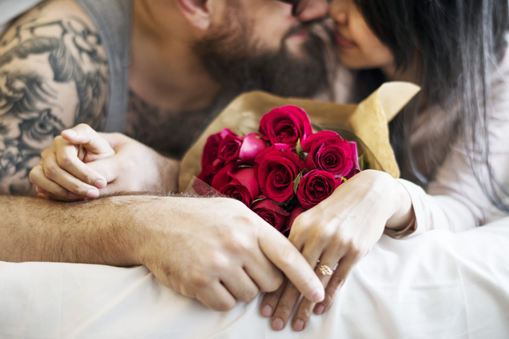 Husband surprised wife with red rose bouquet