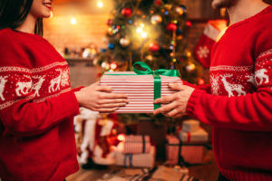 Love couple holding gift box in hands, Christmas