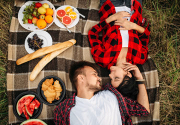 Love couple lies on plaid, top view