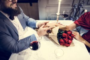 Man with beard giving red rose bouquet