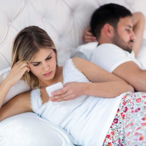Picture of bored young couple in bedroom