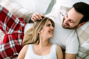 Portrait of young loving couple in bedroom