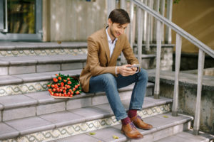 Smiling man texting while looking at the phone