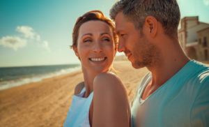 happy mid aged couple on the beach