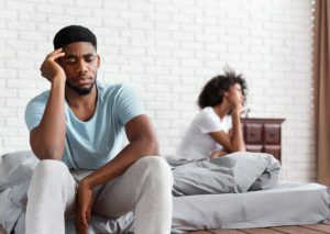 Upset couple ignoring each other in bed