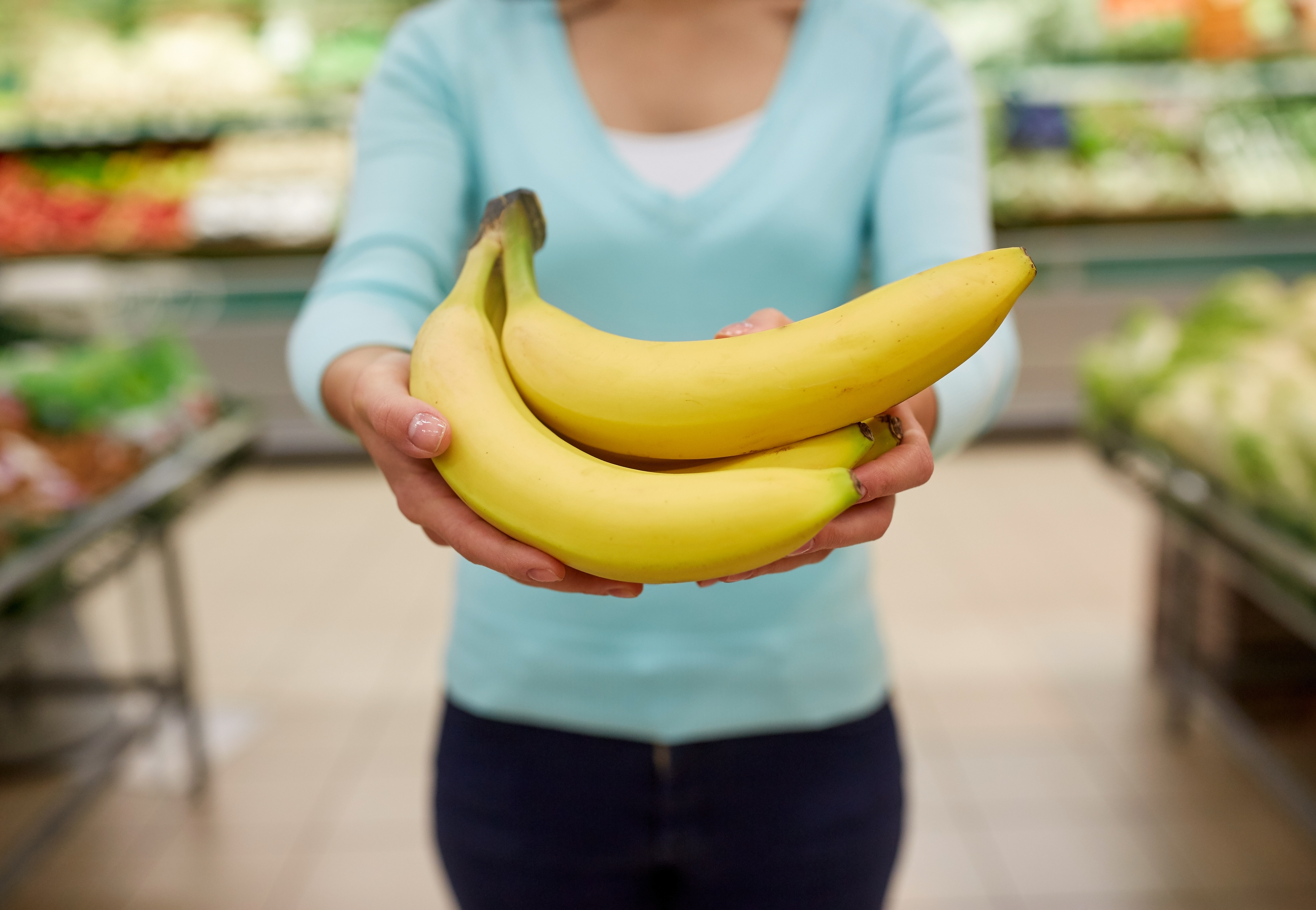 woman with bananas at grocery store