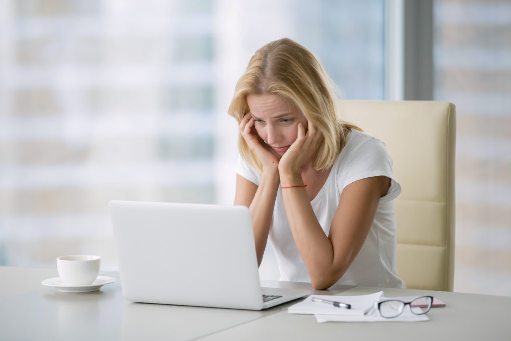 Young hopeless woman at laptop